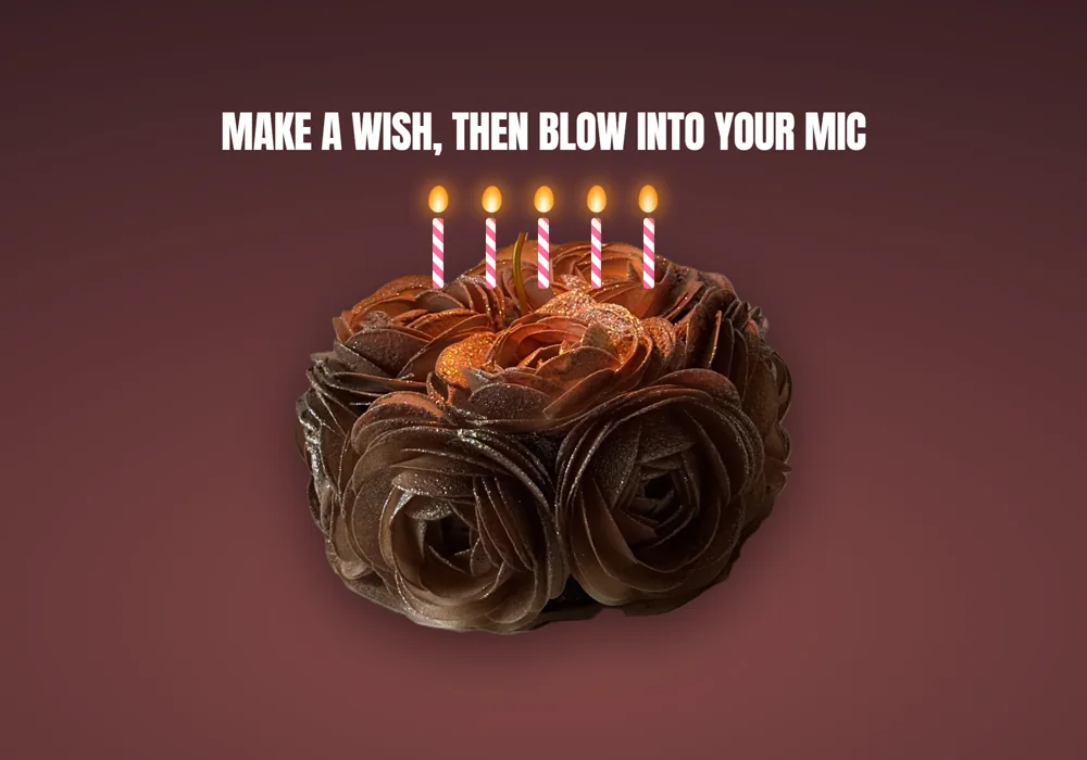 A chocolate cake with five lit candles, above the instruction "Make a wish, then blow into your mic"
